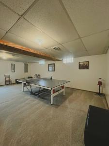 an empty room with a ping pong table in it at Blue Cottage with Game Room Deck & Hot Tub in Logan