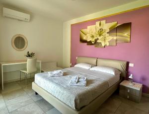 a bedroom with a large bed with a pink wall at Appartamenti Rossini in Bardolino