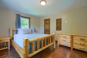une chambre avec un lit en bois et une commode en bois dans l'établissement Tranquil Heights Cabin In Hocking Hills- HOT TUB!, à Londonderry