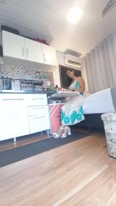 a woman sitting in a bed in a room at Tiny House Aconchego in Canoinhas +7 photos