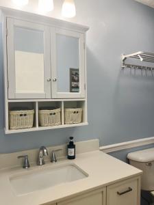 a kitchen with a sink and a white cabinet at Blue Cottage with Game Room Deck & Hot Tub in Logan