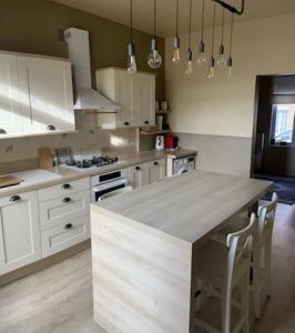 a kitchen with white cabinets and a large counter top at La Jolythalys bord de mer 300m in Étaples
