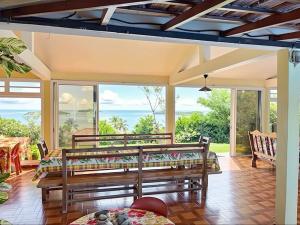 ein Wohnzimmer mit 2 Bänken und einem Tisch in der Unterkunft Villa Belle Frégate in Le François