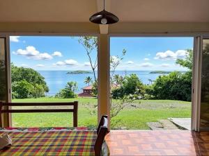 ein Zimmer mit Bett und Meerblick in der Unterkunft Villa Belle Frégate in Le François