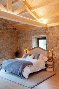 ein Schlafzimmer mit einem großen Bett in einer Steinmauer in der Unterkunft Casa Chare in Moaña