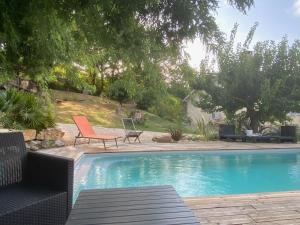 a swimming pool with a chair and a table and a chair at Dépendance atypique 2chbres parc piscine in Villebrumier +13 photos