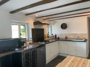 a kitchen with white cabinets and a stove top oven at Dépendance atypique 2chbres parc piscine in Villebrumier