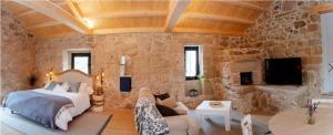 ein Schlafzimmer mit einem Bett und einer Steinwand in der Unterkunft Casa Chare in Moaña