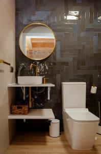 ein Badezimmer mit Waschbecken, Toilette und Spiegel in der Unterkunft Casa Chare in Moaña + 12 Fotos