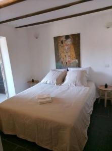 a white bed with two towels on top of it at Dépendance atypique 2chbres parc piscine in Villebrumier