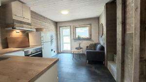 a kitchen and living room with a couch and a table at New apartment for rent in Larvik