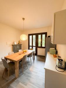 a kitchen and dining room with a wooden table and chairs at Il cuore della valtellina in Caiolo