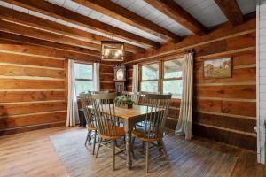 a dining room with wooden walls and a wooden table and chairs at Outdoors Sleeps7 Family Getaway Fun Arcade in Rockbridge