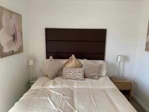 a white bed with two pillows on top of it at Bushmills Boutique Apartment in Bushmills