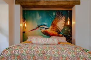 a bedroom with a painting of a bird on the wall at Mijn-Habitat in Valkenburg