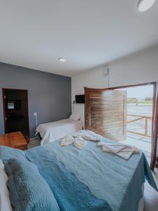 a bedroom with a blue bed and a window at Pacas Suítes Lençóis Eco Lodge in Santo Amaro