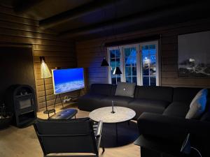 un soggiorno con un divano, un tavolo e una TV di No 105 Kongelberget a Bjorli