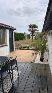a patio with a table and a bench on a deck at La maison heuvelland in Heuvelland