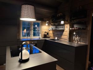 a kitchen with a sink and a lamp on a counter at Fjellhytte med jacuzzi, badstue mulighet in Bjorli