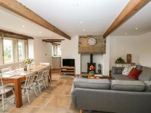 a living room with a couch and a table and a fireplace at Hill Top Cottage in Holmfirth