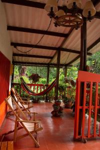 a porch with two chairs and a hammock on it at Casa de campo en medio de encantadores jardines in San Francisco