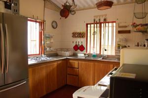 a kitchen with wooden cabinets and a stainless steel refrigerator at Casa de campo en medio de encantadores jardines in San Francisco +35 photos