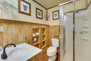 a bathroom with a toilet and a sink and a shower at 3 Mi to Beavers Bend State Park Hot Tub Hideaway! in Broken Bow +17 photos