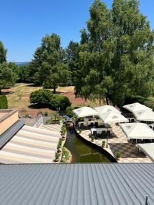 an aerial view of a resort with tables and umbrellas at Hôtel l'Orée des Roches in Saales
