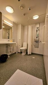 a bathroom with a toilet and a sink and a shower at Hotelli Sammatti in Lohja +14 photos
