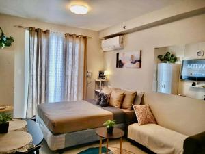 a living room with a bed and a couch at Stayease Studio in Lapu Lapu City