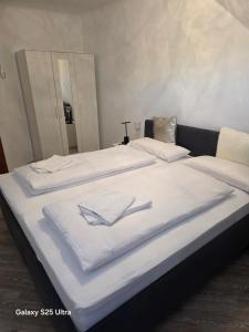 a bed with two white towels on top of it at PEMATRA FeWo Nordlicht in Travemünde