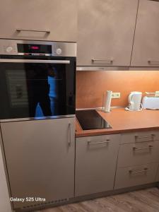 a kitchen with a stove and a microwave at PEMATRA FeWo Nordlicht in Travemünde