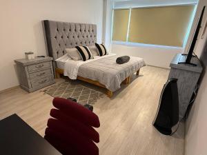 a bedroom with a bed and a television in it at Exclusive Comfort Apartment in Querétaro +22 photos