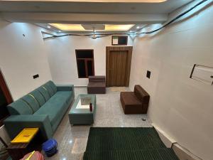 a living room with a couch and a table at Hotel Jyoti Stay Inn 10 Min to Ram Tample in Ayodhya