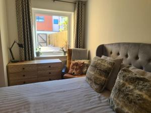 a bedroom with a bed and a dresser and a window at The Snuggery-Hot Tub-Parking-Eco in Topsham