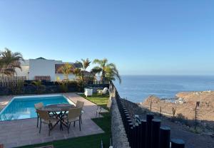 a patio with a table and chairs and the ocean at Villa La Pintora in Playa de Santiago +37 photos
