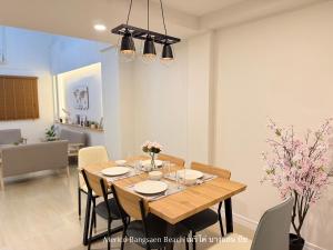 ein Esszimmer mit einem Holztisch und Stühlen in der Unterkunft เมริโค่ บางแสน บีช Merico Bangsaen Beach in Ban Laem Thaen