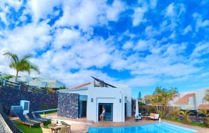 a woman standing in front of a house with a swimming pool at Villa La Pintora in Playa de Santiago