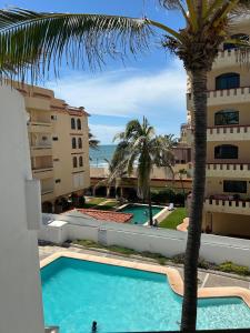 a view from the balcony of a hotel with a palm tree at Marina del Sol Resort Condo directly on the Ocean 102 in Mazatlán