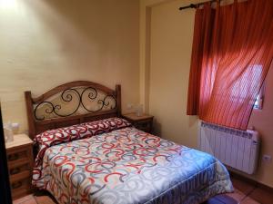 a bedroom with a bed and a red curtain at Casa Béjar in Quesada