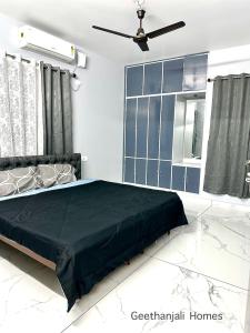a bedroom with a bed and a ceiling fan at Geethanjali Homes in Kanyakumari