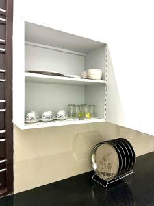 a kitchen shelf with plates and dishes on it at Geethanjali Homes in Kanyakumari