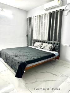 a bed in a white room with a window at Geethanjali Homes in Kanyakumari +20 photos