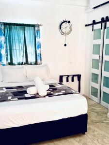 a bedroom with a bed and a clock on the wall at The PoolSide Pad- 5 mins from Airport & Beaches in Bon Accord +21 photos