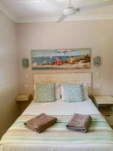 a bedroom with a bed with a painting on the wall at Banana Beach Getaway in Port Shepstone