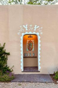 a wall with a door in the side of a building at Dos Hermanas Compound 7 Casitas Downtown in Santa Fe