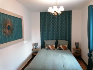 a bedroom with a bed and a green wall at La maison du père Bellessort in Régnié