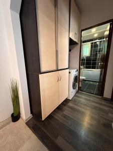 une cuisine avec un réfrigérateur et une machine à laver dans l'établissement Apartament Iasmina, à Petroşani