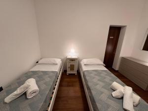 two beds in a small room with towels on them at Sweet charm in Venice in Tessera