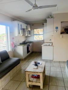 a living room with a couch and a table at Banana Beach Getaway in Port Shepstone